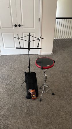 Practice snare drum with percussion implements, music stand, and metronome.