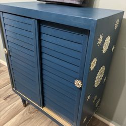 Hand painted Shutter Door Storage Cabinet With Floral Decor Painted In Pearl White And Metallic Gold 