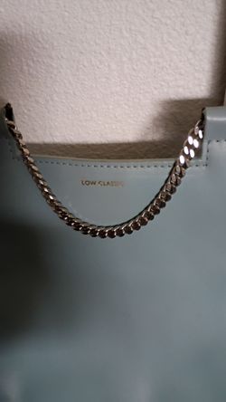 Light blue crossbody purse, silver chain strap.