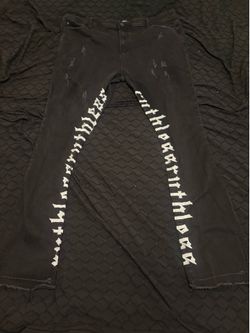 Black stacked jeans with white lettering