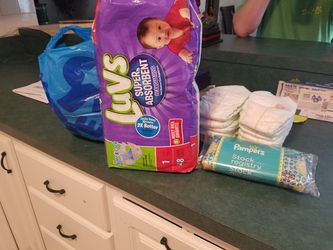 2 pks Luvs size 1 diapers plus 15 newborn diapers and accessories