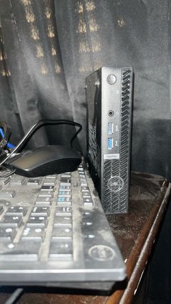 Dell Vpro D15U micro desktop with monitor mouse and keyboard.