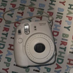 Fujifilm Instax instant camera in white. 