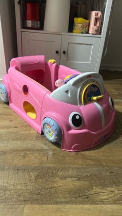Girls sit in toy car with sounds