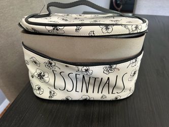 white and black floral toiletry bag with the words 'ESSENTIALS'