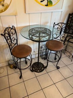 High top glass table with two chairs.. 32” around x 44” high $100