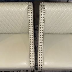 2 double studded bar height leather chairs
