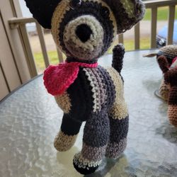 Hand crocheted black, gray, white and tan dog with heart collar.