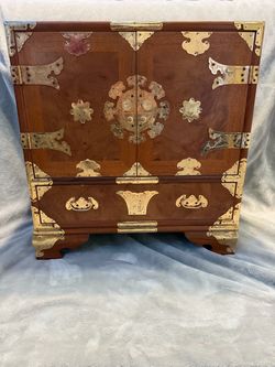 ornate wooden storage chest with Asian-inspired decorative hardware.