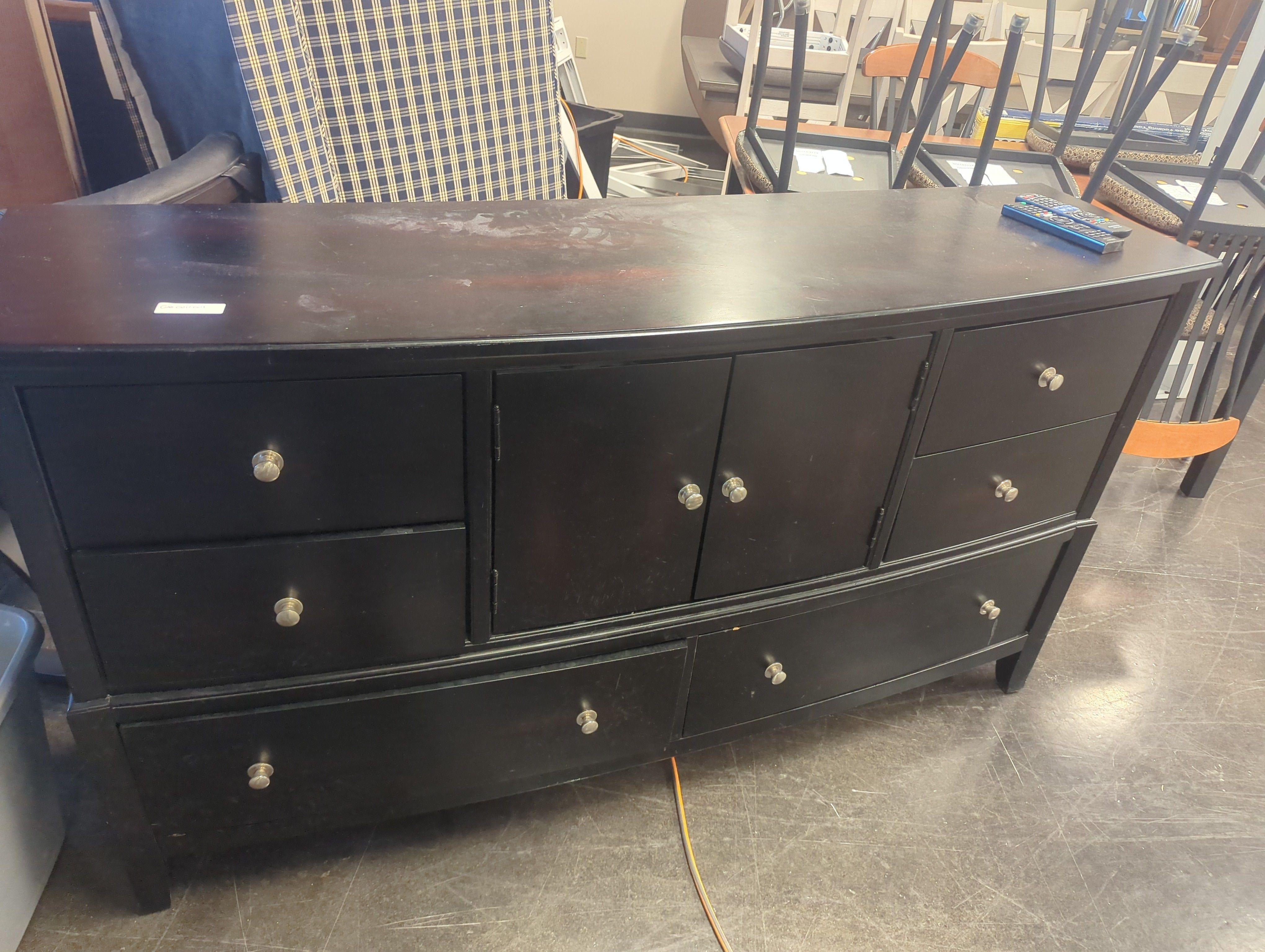 Curved black dresser with silver knobs