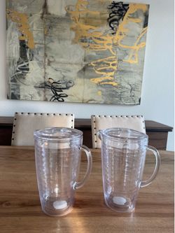 Two heavy plastic pitchers with lids