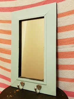 Pale blue mirror with hooks