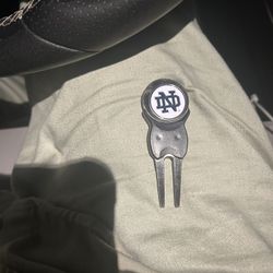 golf divot tool with a removable Notre Dame ball marker.  Used to repair pitch marks on a golf green
