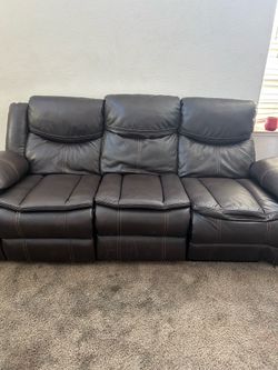 Brown leather couches with a four recliners