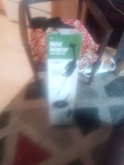 Metal detector with arm