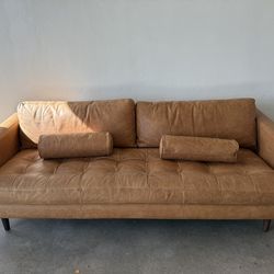 Brand New Leather Couch, gently used gold framed mirror, gold colored metal coffee table.