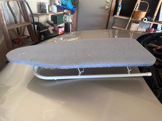 tabletop ironing board featuring a folding white metal frame