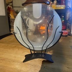 clear glass flower vase with a black metal stand. 