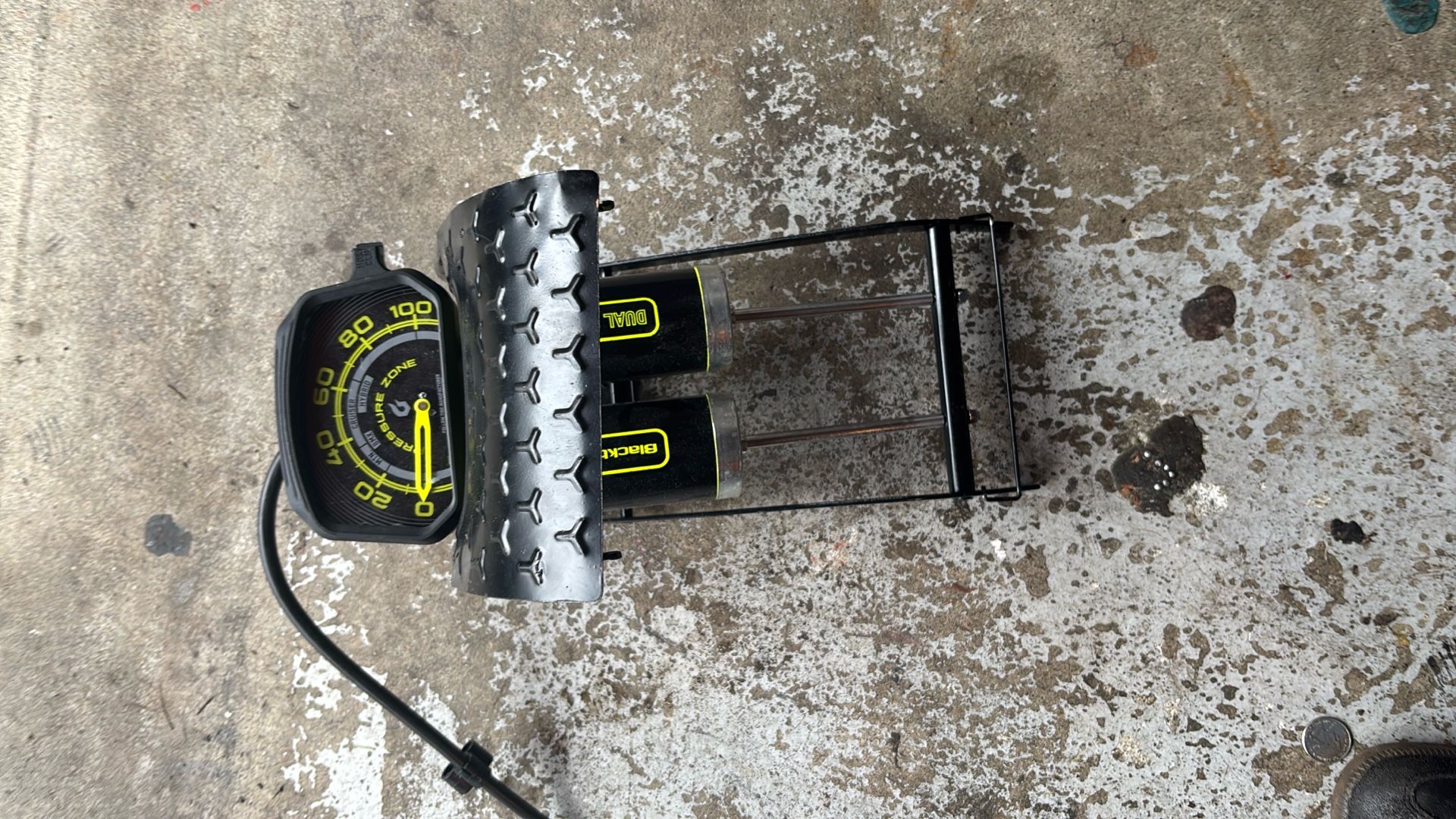The pump has a dual-barrel mechanism and a dual pump head that is compatible with both Schrader and Presta valves. It features an oversized,
