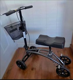 KNEE WALKER/SCOOTER:  FOLDABLE, ADJUSTABLE, DUAL HAND BRAKES, BASKET. GREY FRAME. EXCELLENT CONDITION!