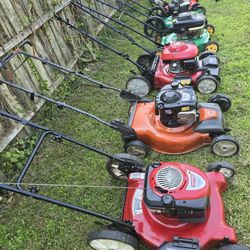 A group of lawn mowers for sale, prices are in the description