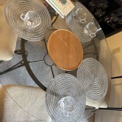 Table with a glass top and 4 chairs.