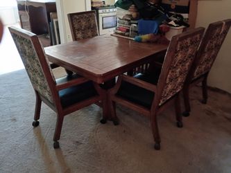 Dinning table with four high back chairs with rollers