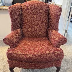 Queen Anne-style upholstered wingback armchair traditional-style wingback accent chair with cabriole legs, upholstered in a red and gold brocade. 