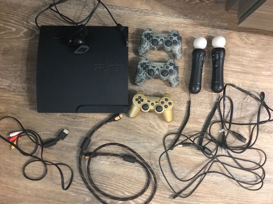 Black sony ps3 slim console with controllers