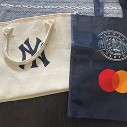 Navy and white Yankees tote bags from games at Yankee Stadium