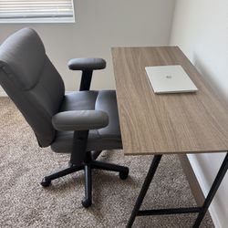 Very comfortable, leather study chair with adjustable armrests, along with a woody study table.