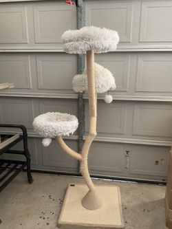 A multi-level cat tree featuring a design that mimics natural tree branches, complete with beds line