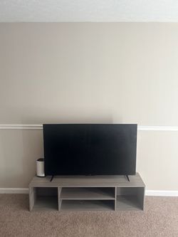 Grey wooden low sitting TV stand