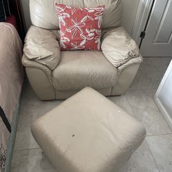 Beige leather armchair accompanied by a matching ottoman