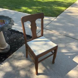 Vintage wooden chair with T-back design and light-colored padded seat