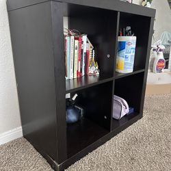 Black 4-cube storage shelf .