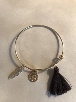 Women’s gold bangle bracelet with charms.
