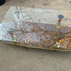 A Nice Glass Coffee Table With 4 Statues Holding The Glass (47” Long X 18” Wide) The Glass Is Shorter (35” X 24”)