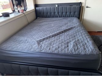 Grey queen size bed frame with charging ports on headboard