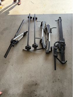 several Thule branded roof rack components, including crossbars and bike carriers.
