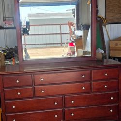 traditional cherry wood dresser with an attached arched mirror