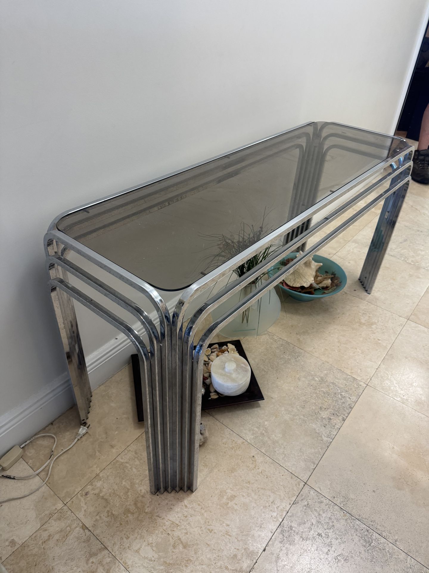 1970s vintage chrome and smoked glass console table, often featuring a waterfall design