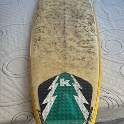 surfboard with a traction pad featuring a pine tree design. Type: Hybrid model, designed to blend stability and maneuverability.