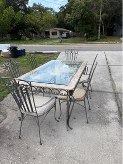 Cast iron tables, dinning table, 2 end tables and a coffee table. All glass is present and everything is in like new condition. 6 chairs, 2 with arms 