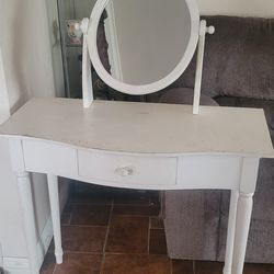 Vanity table with an oval mirror and single drawer