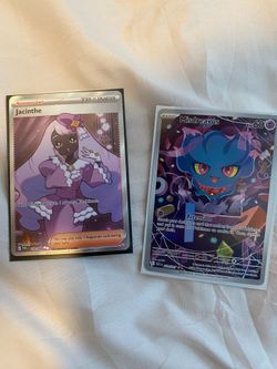 Mix of Pokémon cards, pins, and two mats