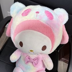 Design: Features My Melody wearing a cute bear hood with a round, gentle face. Colors: Soft pastel rainbow tones — pink, blue, yellow, and lavender — 