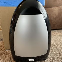 stationary vacuum cleaner that automatically activates when debris is swept near its inlet.