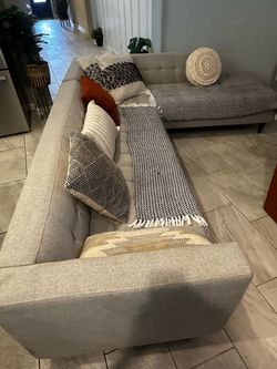 large L-shaped sectional sofa with a chaise, upholstered in a light gray/beige textured linen or linen-blend fabric