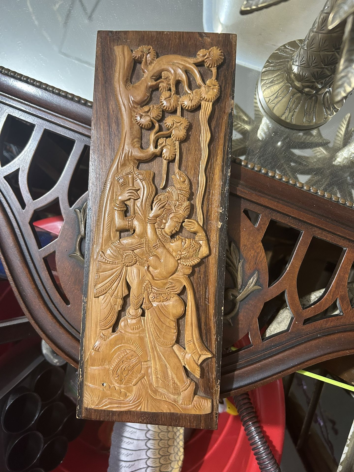 vintage Asian wood carving, a Balinese wooden wall hanging. It depicts a scene featuring a male figure, possibly a deity like Krishna,